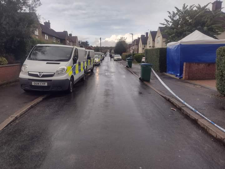forensics vans and police cars opposite the cordoned off house.